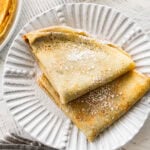 two crepes on a plate with recipe ingredients nearby.