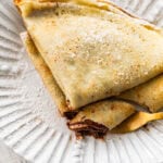 two crepes on a plate with recipe ingredients nearby.