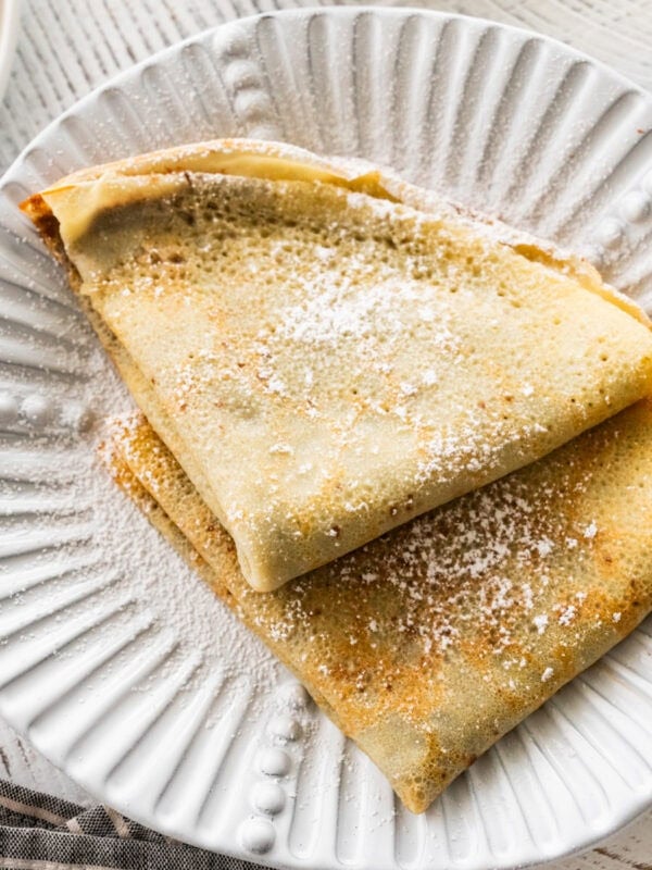 two crepes on a plate with recipe ingredients nearby.