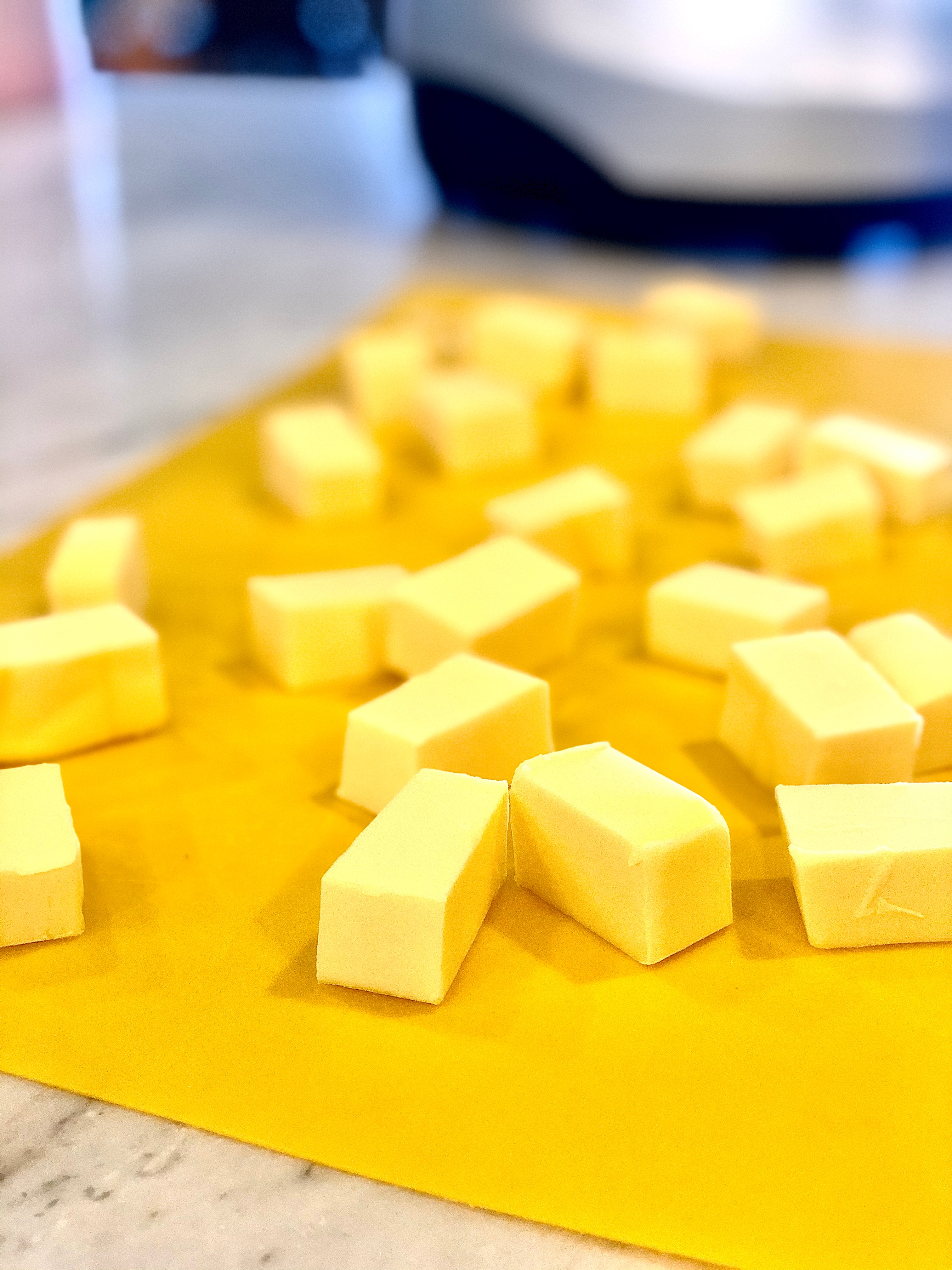 Process for makingUltimate All-Butter Pie Crust Recipe. butter cut up on a cutting board.