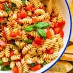 fresh tomato basil pasta on a blue and white serving bowl.