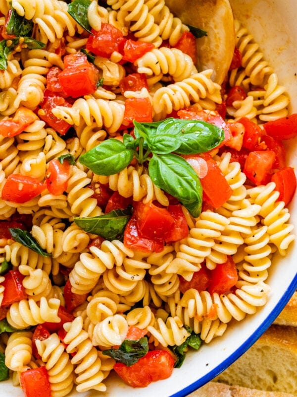 fresh tomato basil pasta on a blue and white serving bowl.