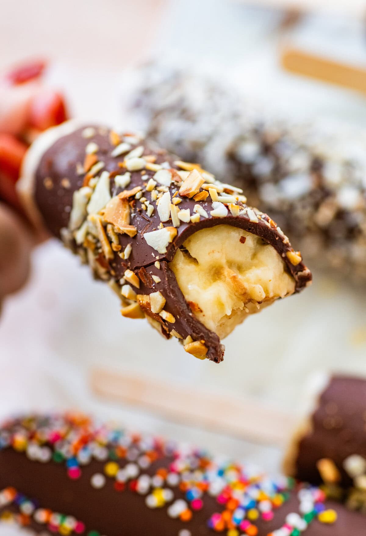 One chocolate dipped banana with a bite taken out of it.