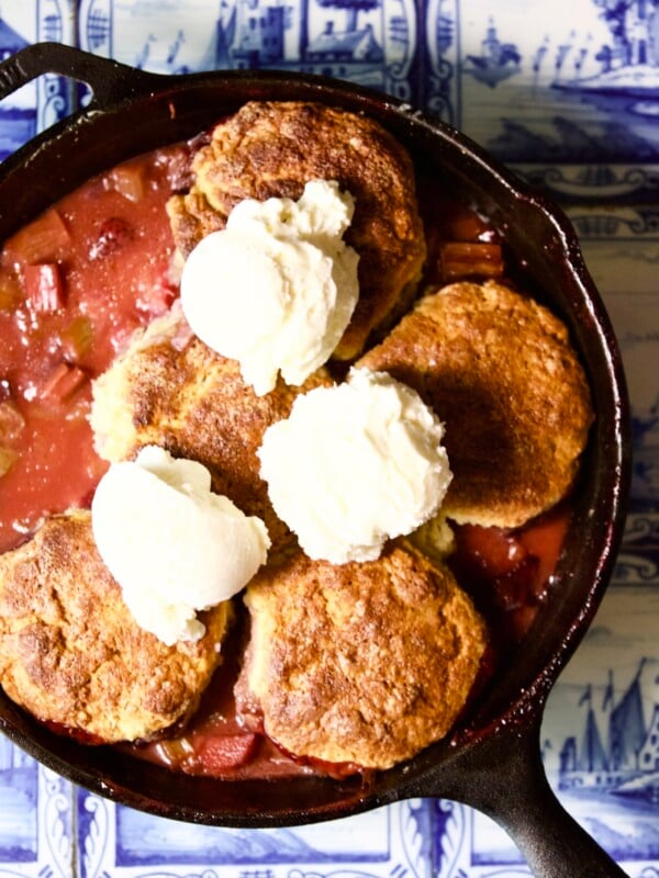 Fresh strawberry rhubarb biscuit cobbler with homemade vanilla bean gelato in a skillet.