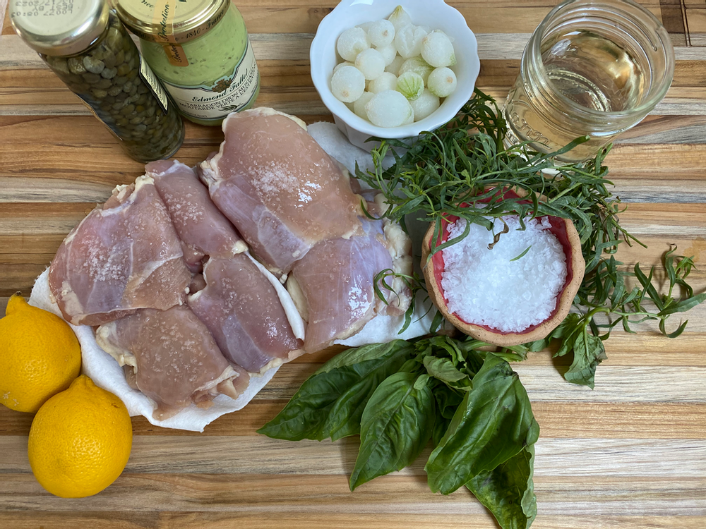 Raw ingredients for chicken recipe on a wood counter.