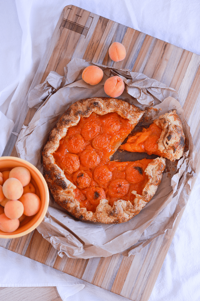 Apricot galette on a wood cutting board.