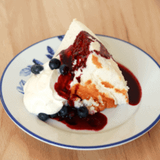 Slice of angel food cake with toppings on a plate.