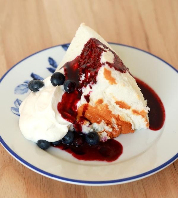 Slice of angel food cake with toppings on a plate.