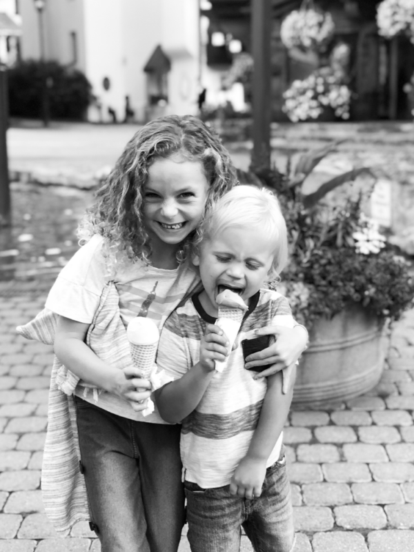 Black and white photo of two children with cones of gelato.