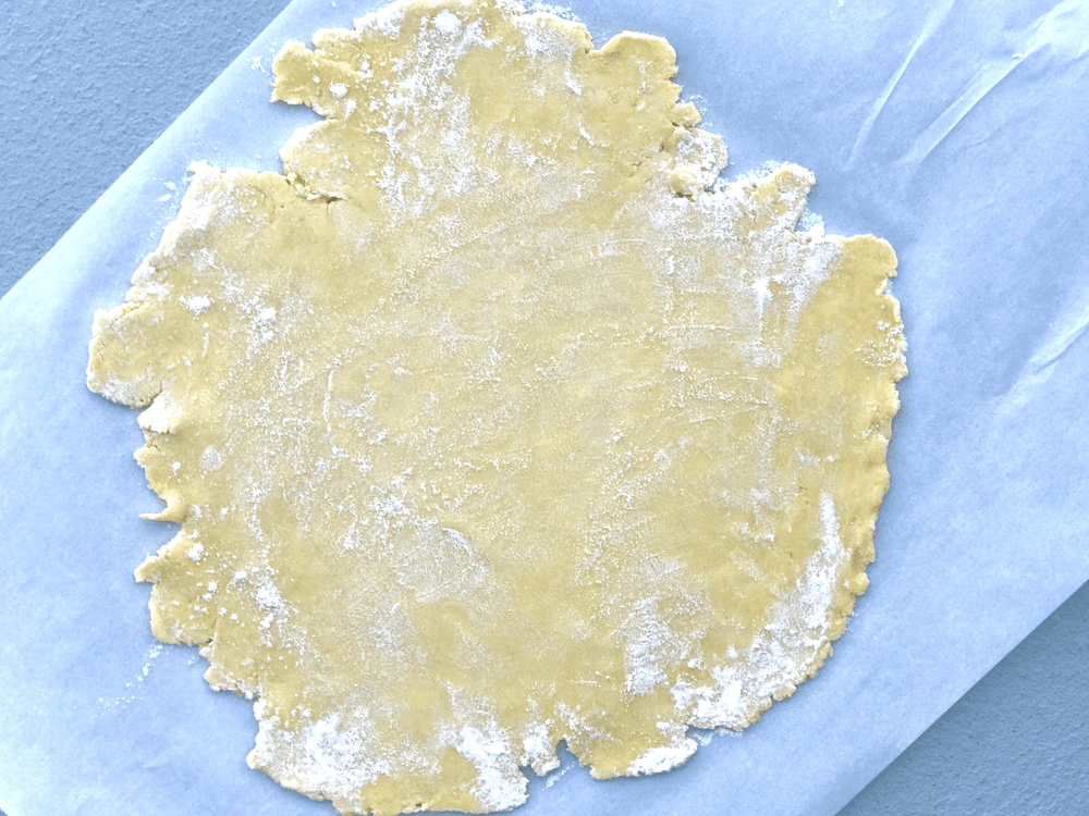 Rolled out pie crust on parchment paper.