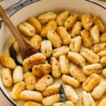 Gnocchi mixed with sauce in a large pot.