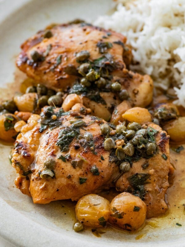 tarragon chicken thighs on a plate with rice.