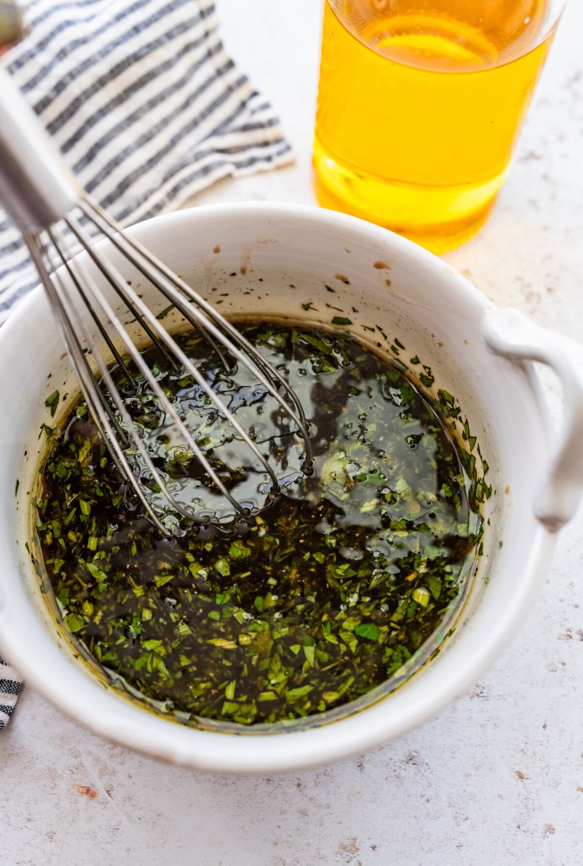 Whisking the olive oil and herbs together.