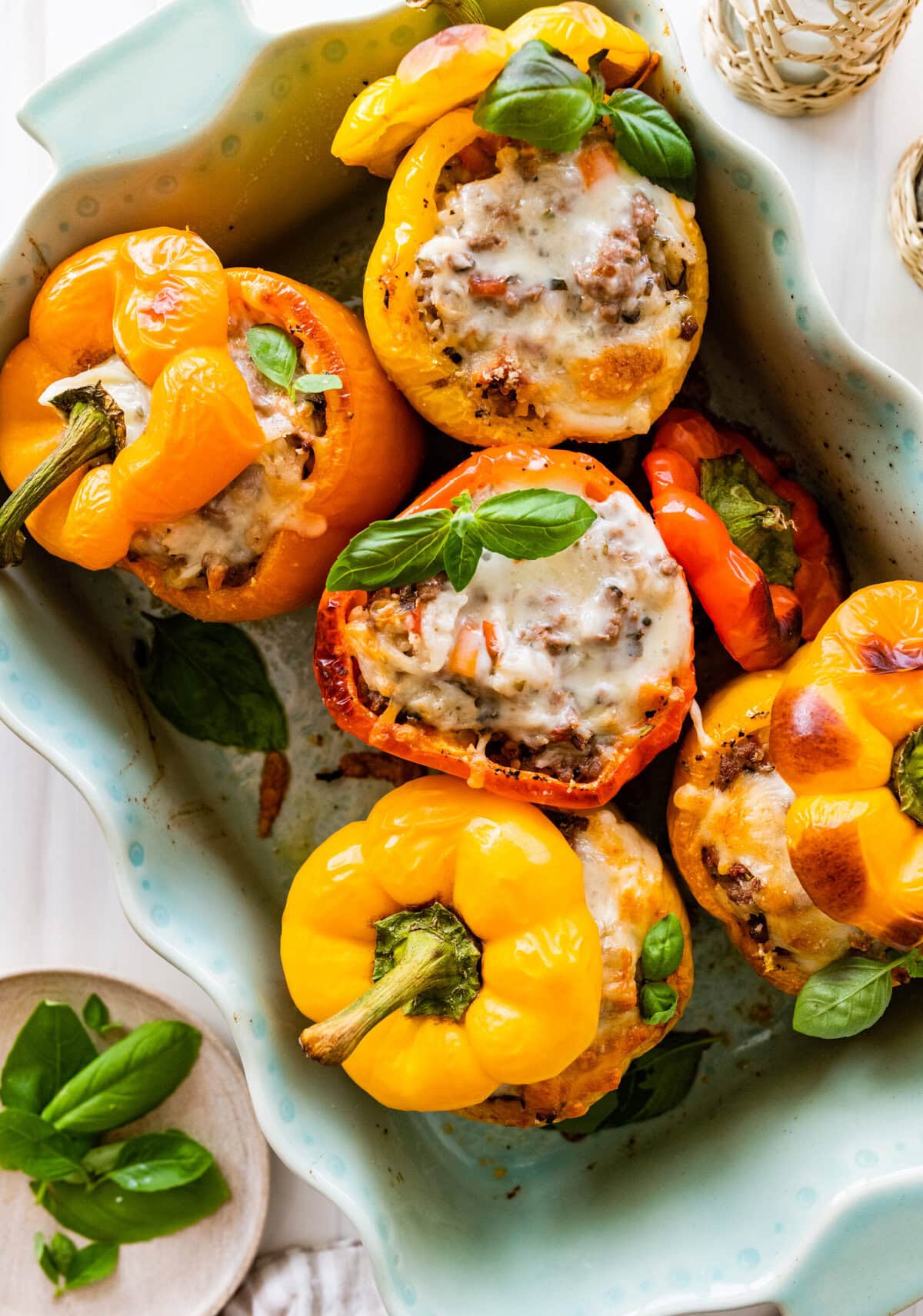 Baked stuffed bell peppers in a white baking dish.