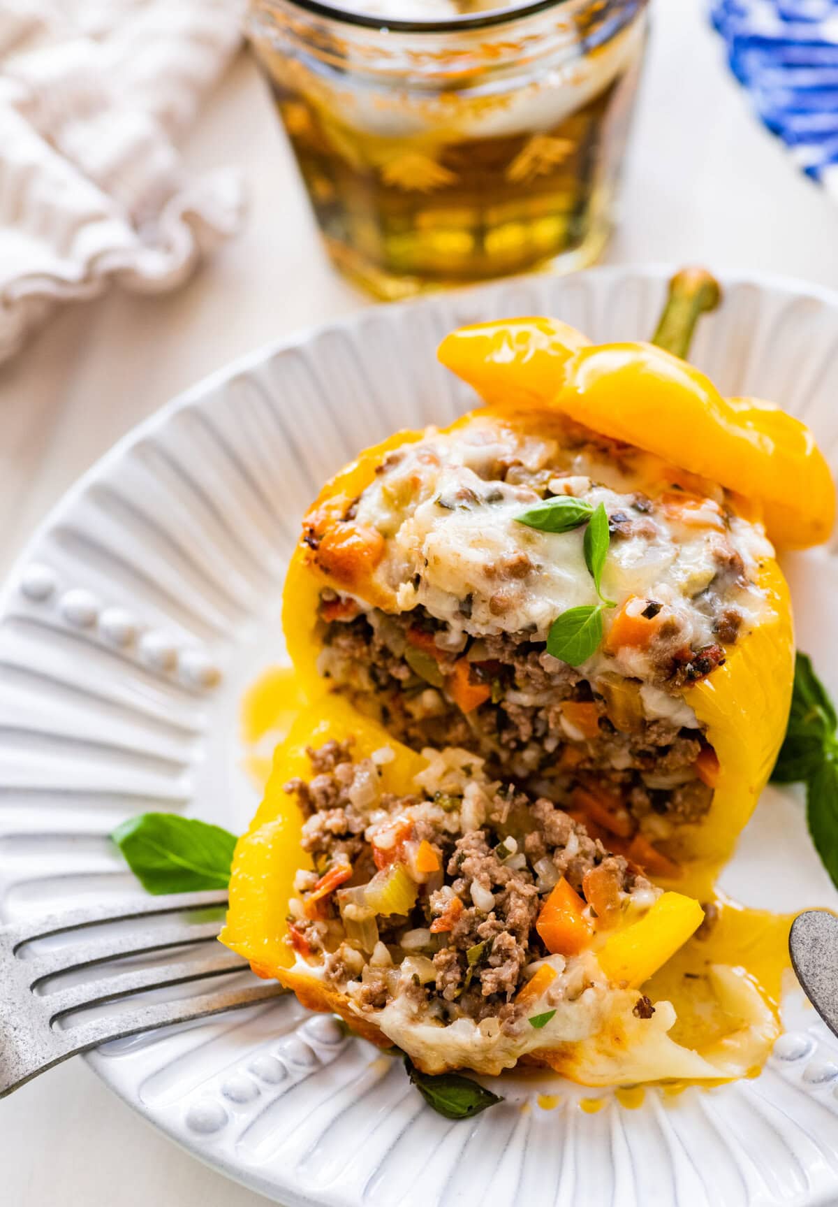 An Italian stuffed bell pepper on a plate cut to show the beef and rice filling on the inside.