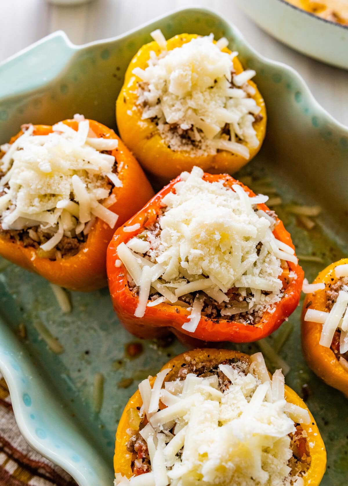 Adding cheese on top of the peppers.