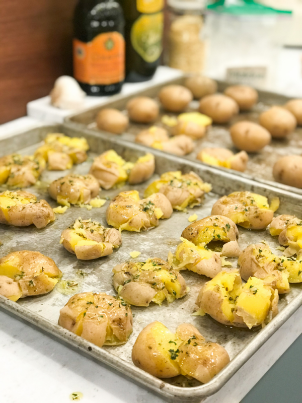 Smashed garlicky herb potatoes on a baking sheet.