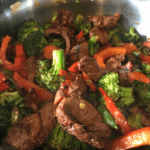 Orange marinade steak stir fry in a wok.