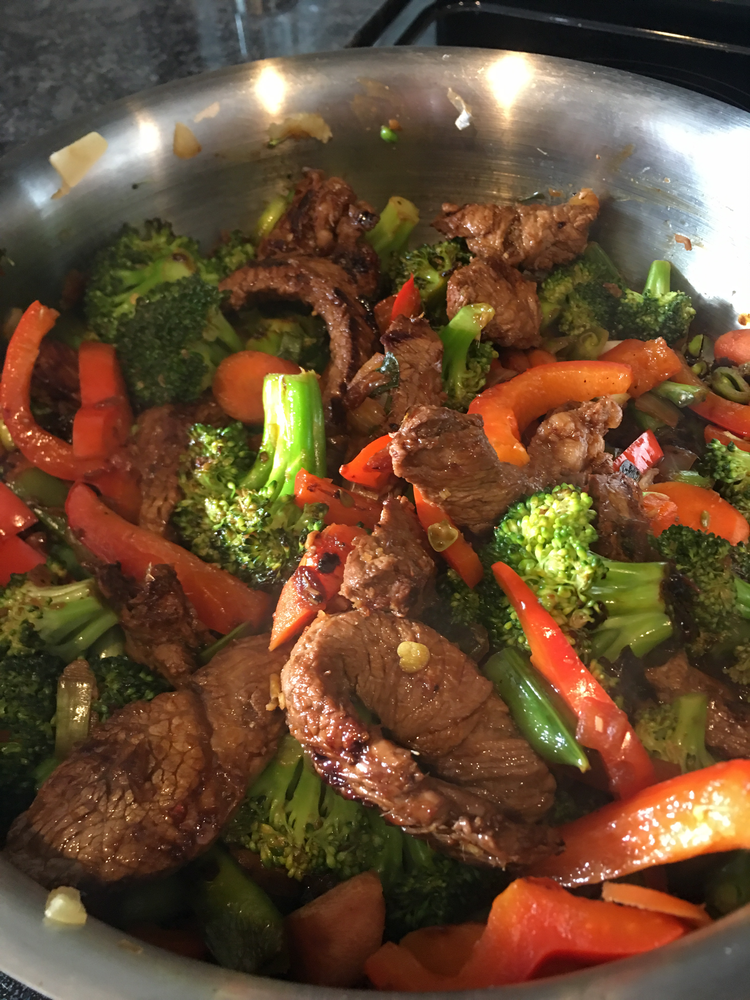 Orange marinade steak stir fry in a wok.
