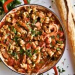 Trottole Pasta Recipe with Tomato Sauce and Shrimp in red enamel pan bread on the side.