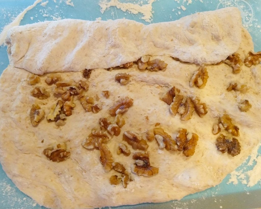 Rolling the bread dough with the walnuts to form into log and then bake. 