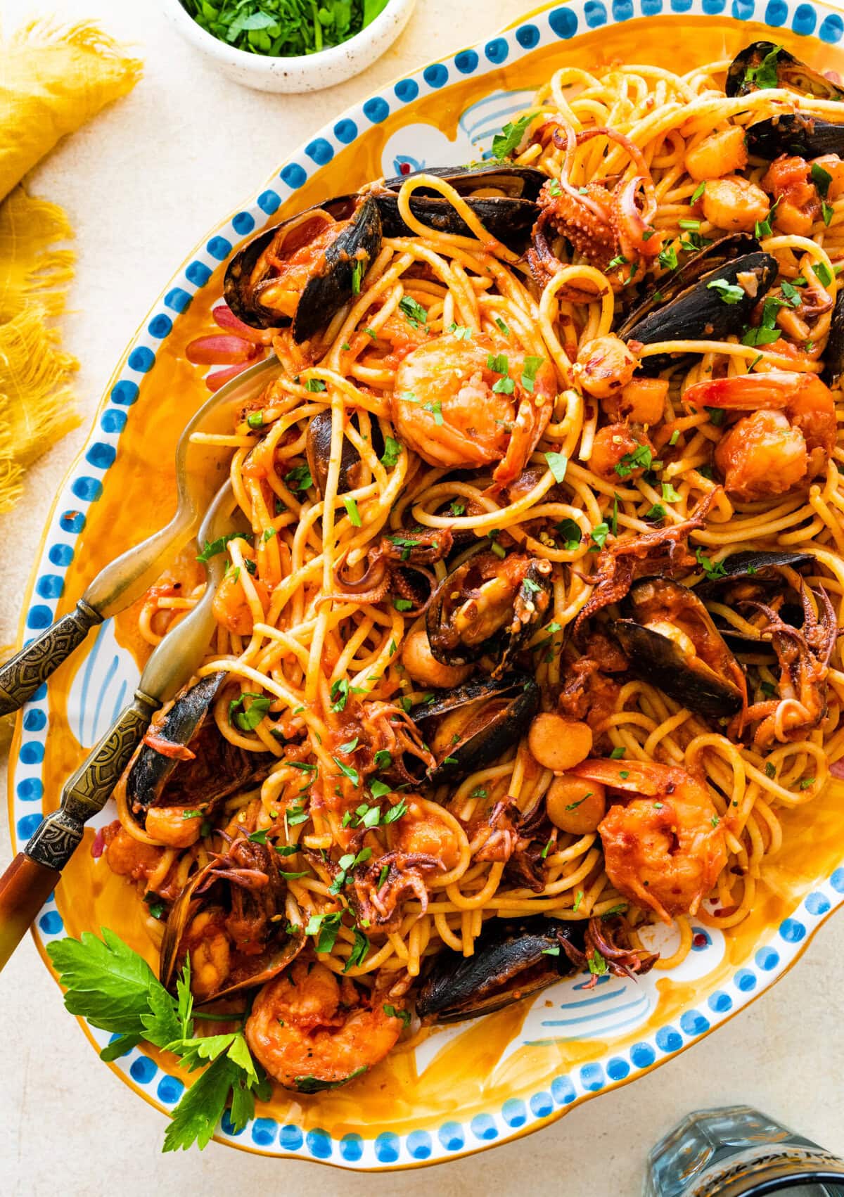 A plate of frutti di mare pasta on a white and blue sering platter.