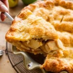 A piece of apple pie being removed from the pie dish.