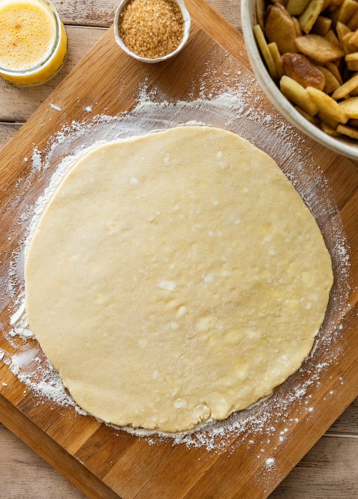The pie crust rolled out with more of the recipe ingredients nearby,