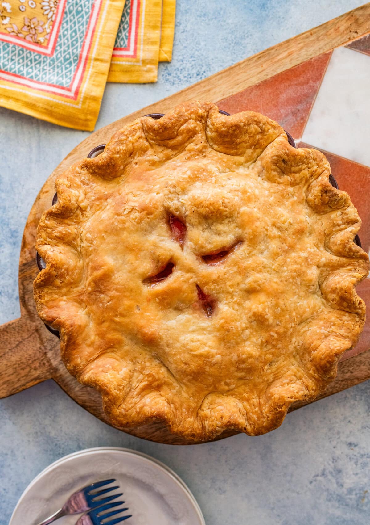 rhubarb pie after baking, with a serving spoon nearby.