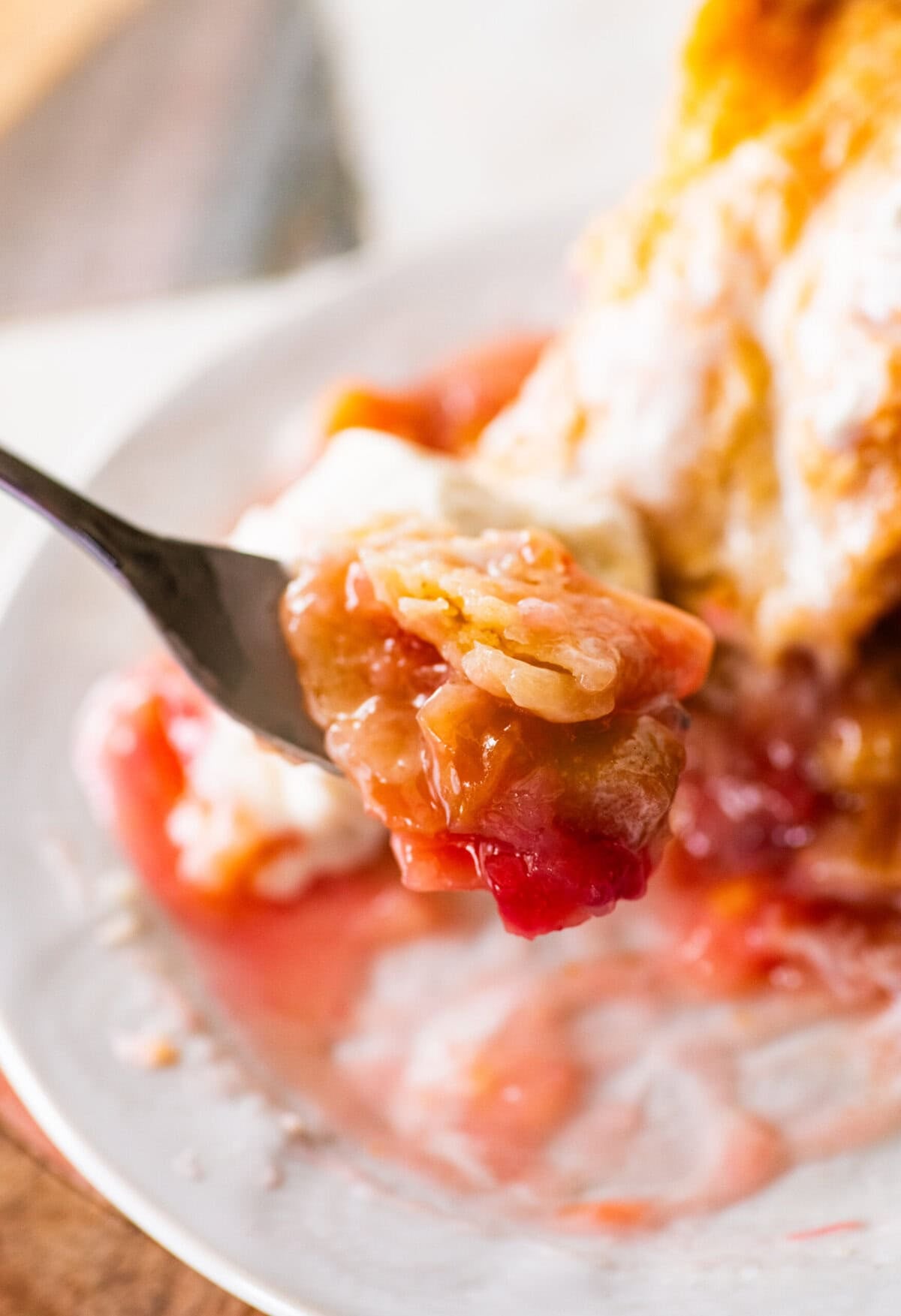 a slice of rhubarb pie with a bite taken out on a fork.
