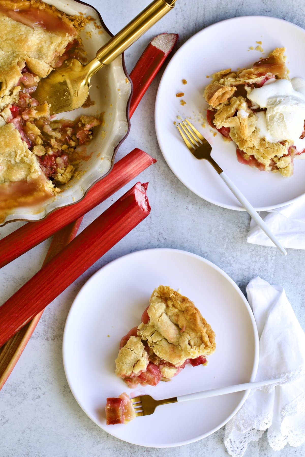 Slices of rhubarb pie on plates with ice cream