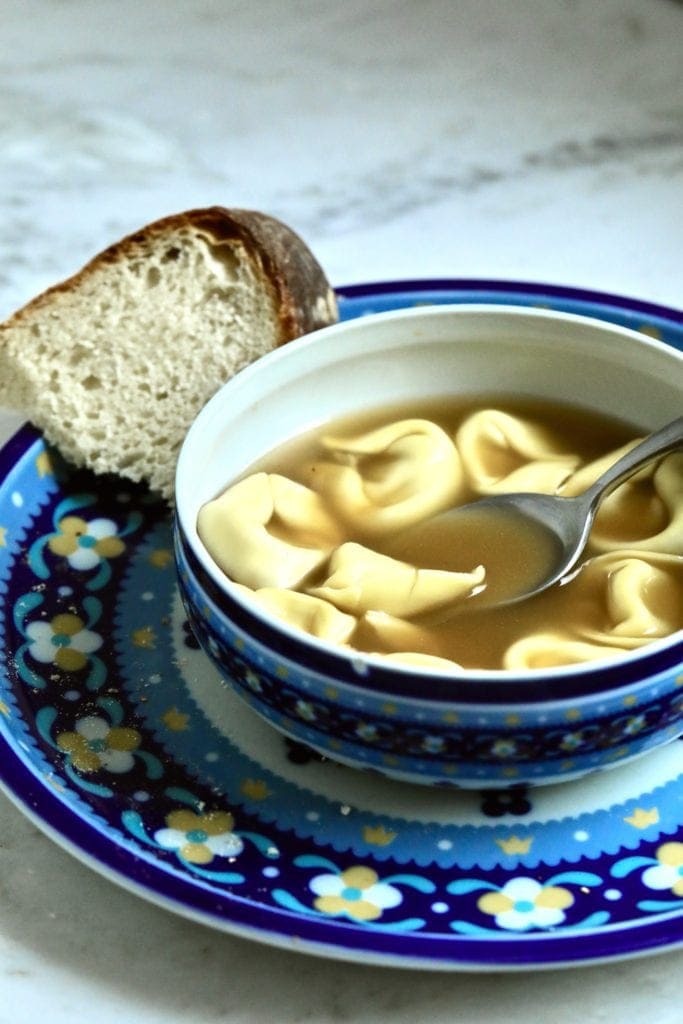 soup-tortellini-cheese in a bowl with bread. 