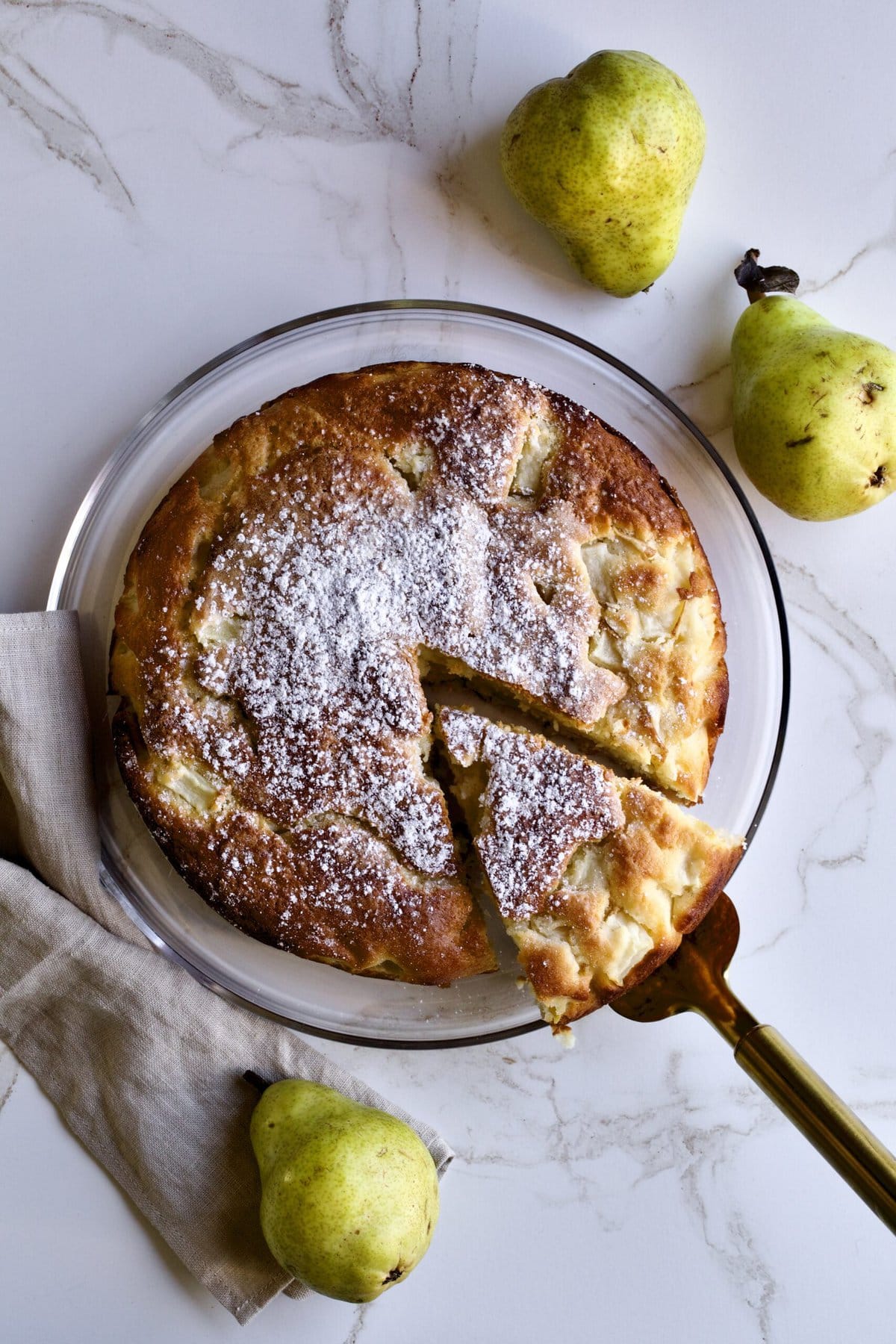 Spatula removing a slice from an Italian pear cake.