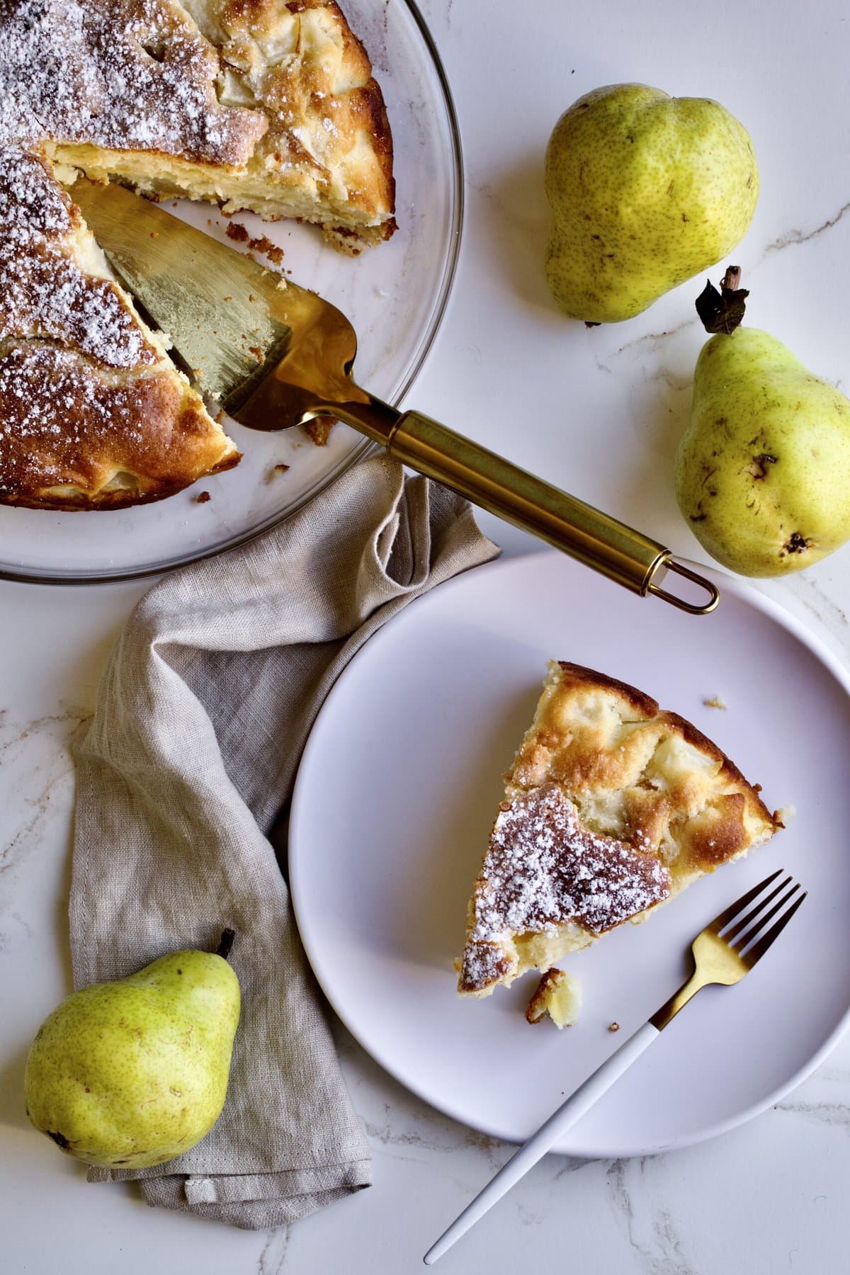 Italian pear cake recipe. Slice of cake on a plate with fresh pears as the background.