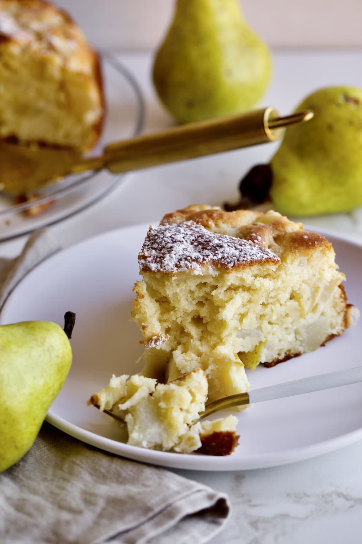 thick slice of Italian pear cake on a plate with a fork.