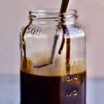 chocolate syrup in Mason jar with drip. Spoon inside jar.