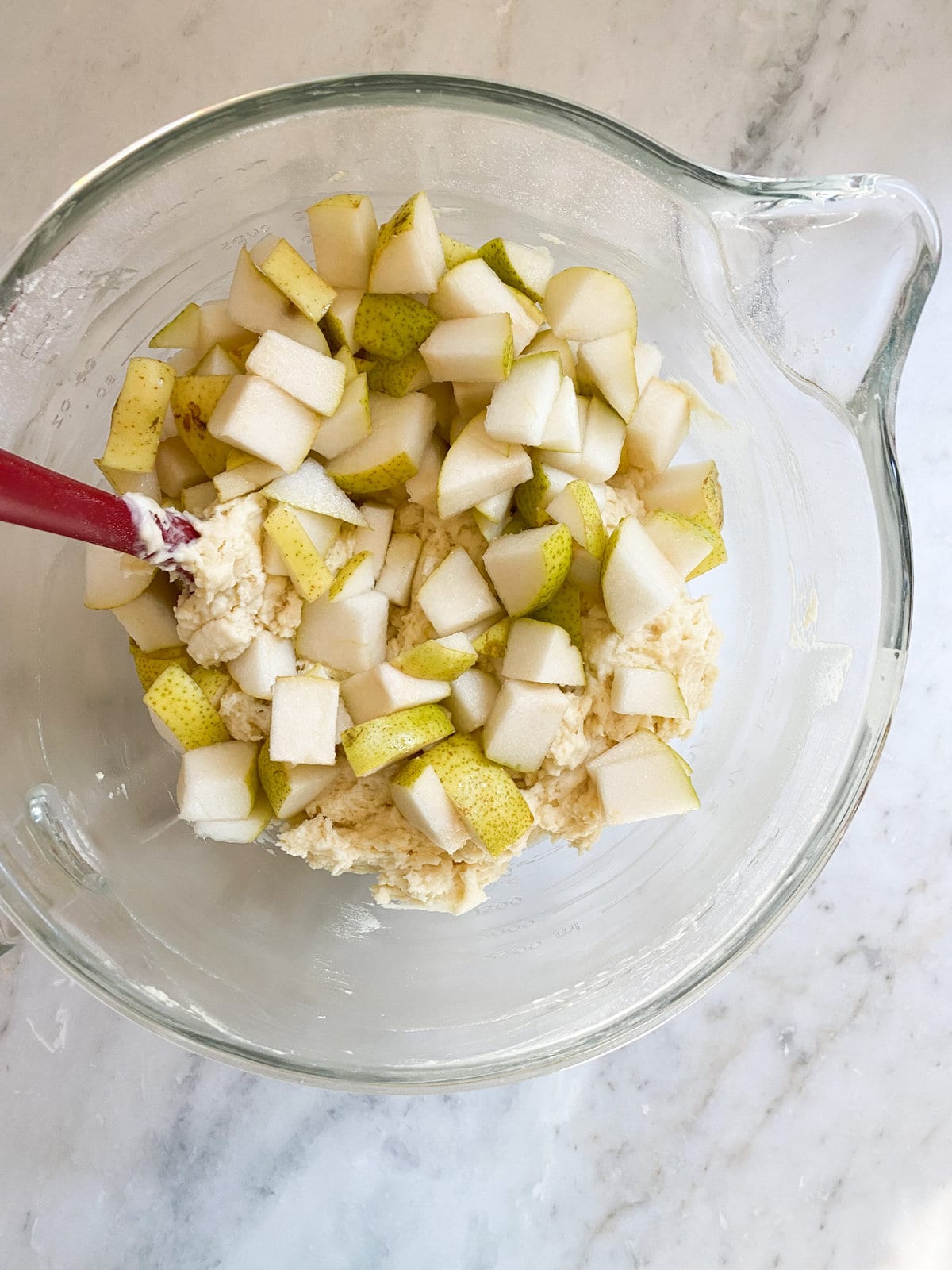 mixing the pear cake batter with the fresh pears until combined.