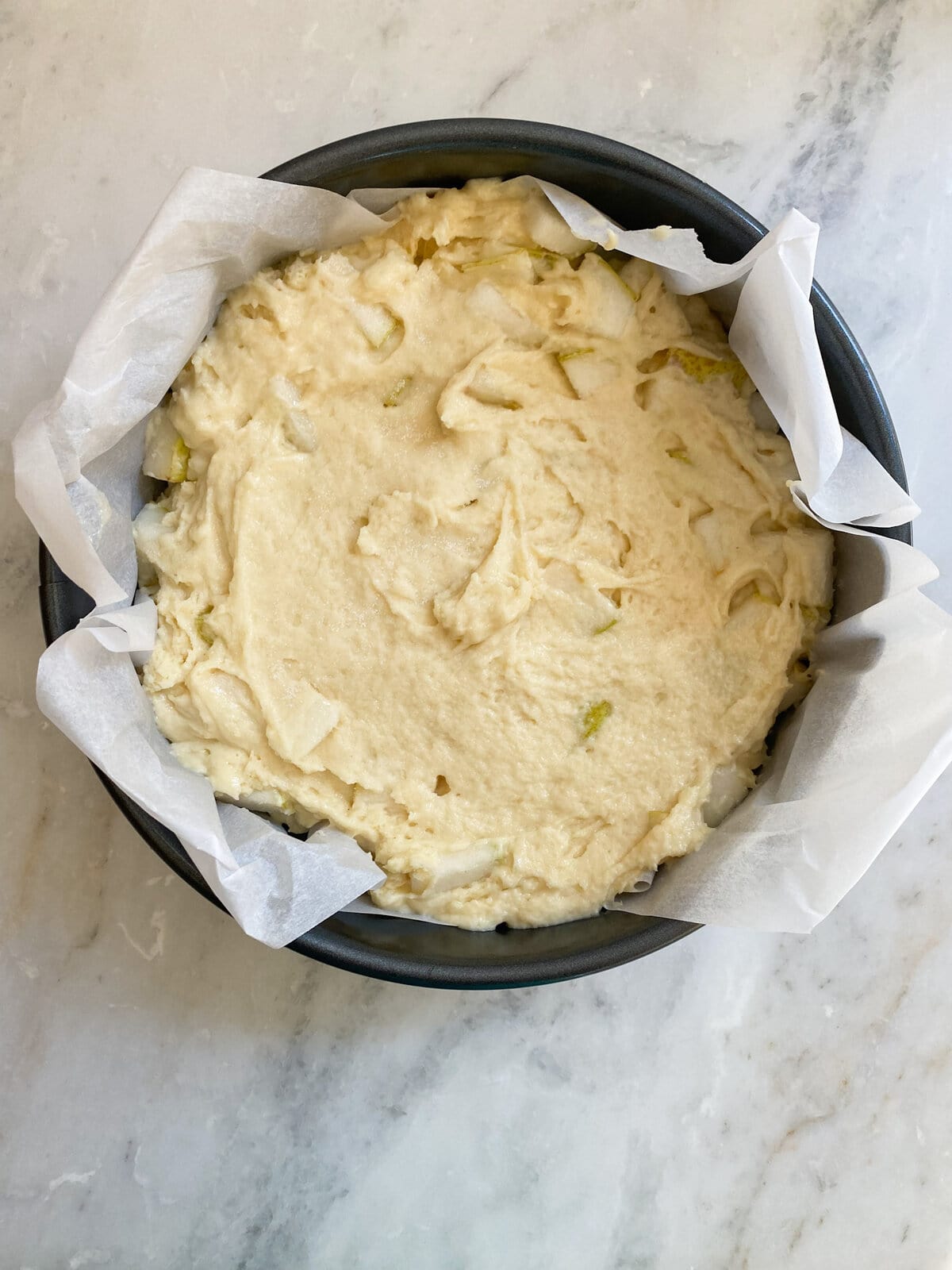 placing final cake batter in prepared cake pan.