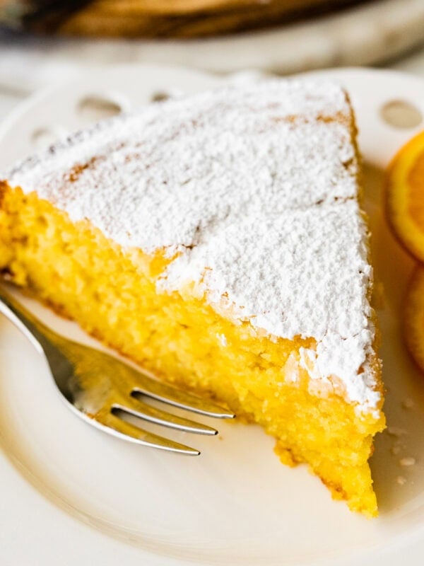 slice of cake on a plate with a fork ready to eat.