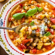 Spoon scooping from a bowl of Italian minestrone.