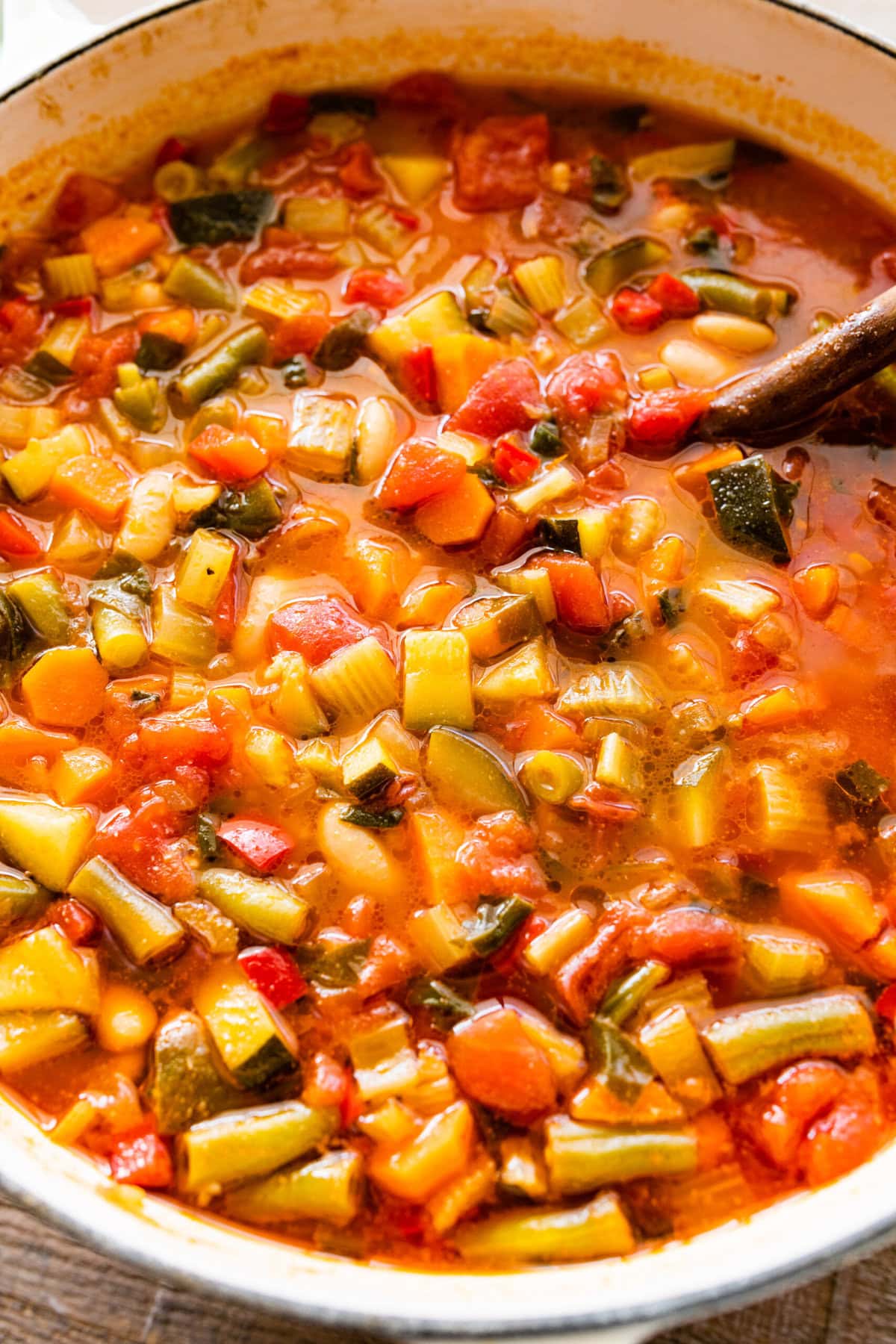 cooked minestrone soup stir with a wooden spoon.