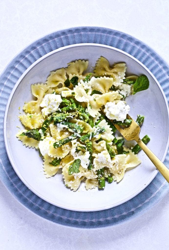 Lemon ricotta pasta with asparagus in a bowl with a fork.