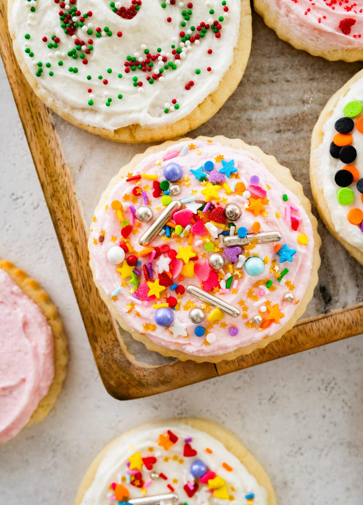 Decorated frosted sugar cookies on a plate and on the table.
