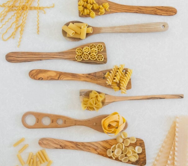 different pasta shapes with wooden spoons