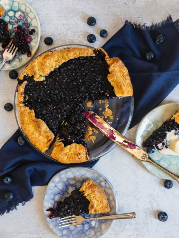 Knife with a partially-sliced blueberry galette.
