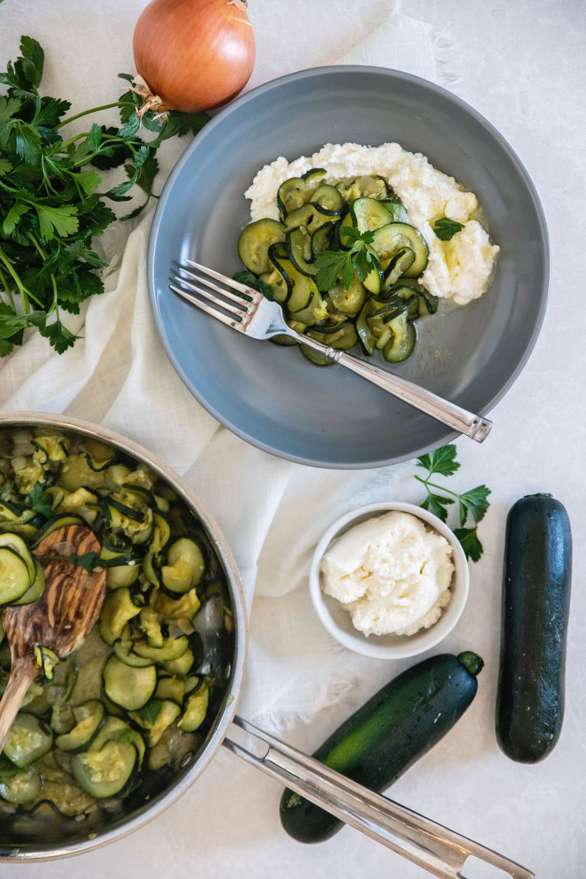 fresh onions and zucchini with a bowl of ricotta to show the ingredients in this dish