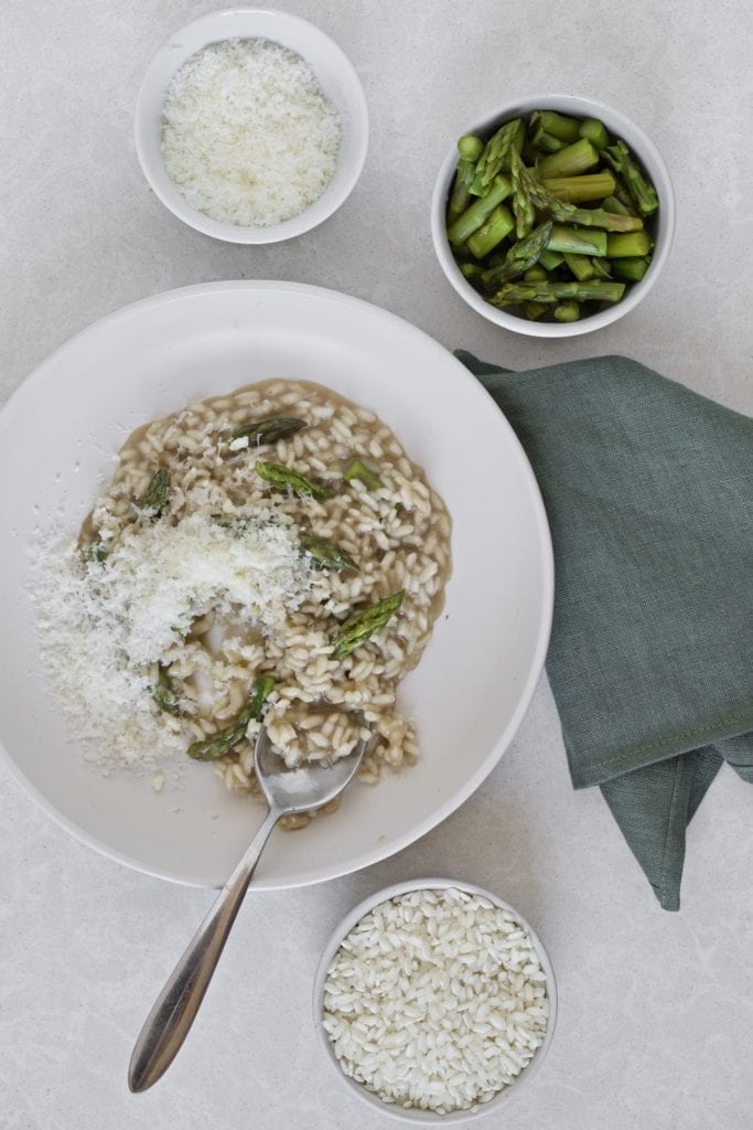 bowl of risotto with ingredients displayed on side.