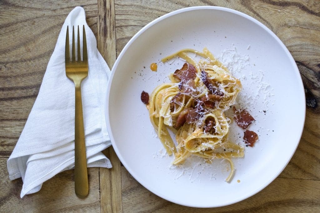 carbonara on a plate with wooden board