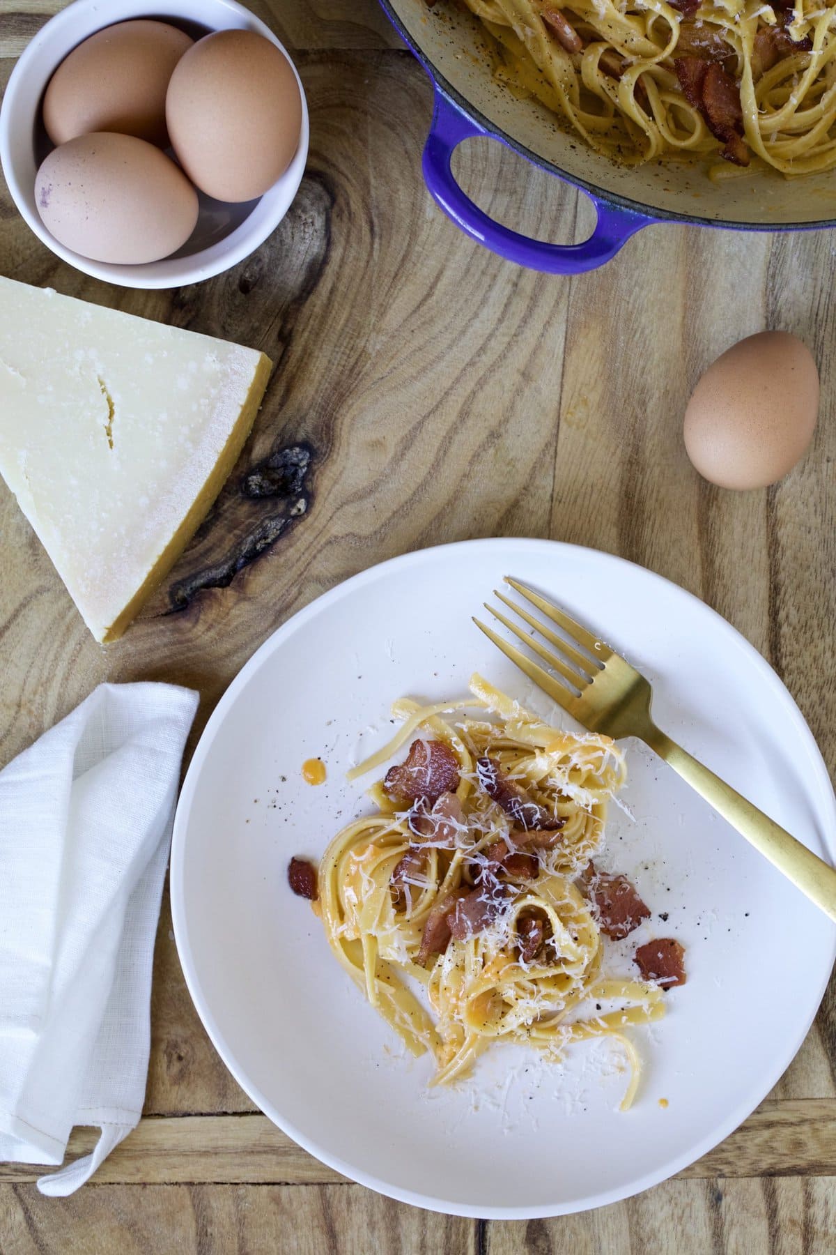 Authentic Italian pasta carbonara on a plate with wooden board as background. 