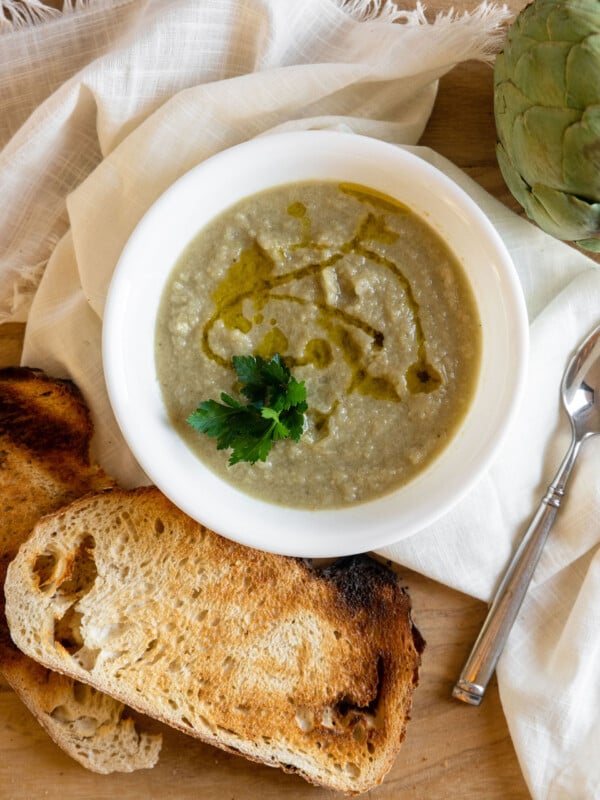 artichoke soup in a bowl with toasted bread